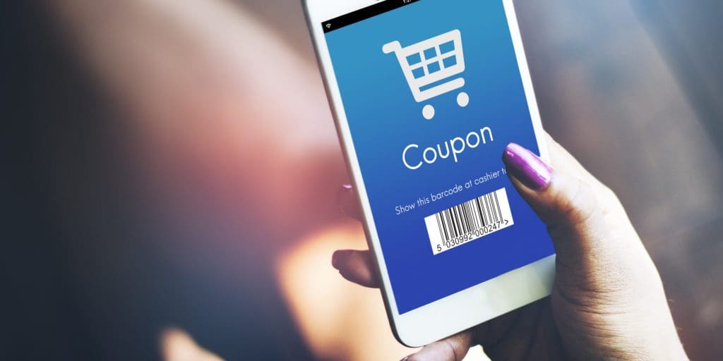 A woman scans a mobile coupon from an eCommerce loyalty program app on her smartphone to save money while shopping in-store.