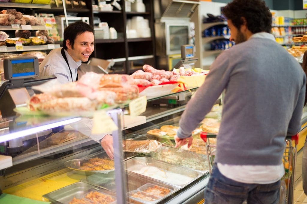 Supermarket Shopkeeper serving a customer in a grocery store.